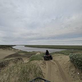 Taylor and Justin driving an ATV to the river